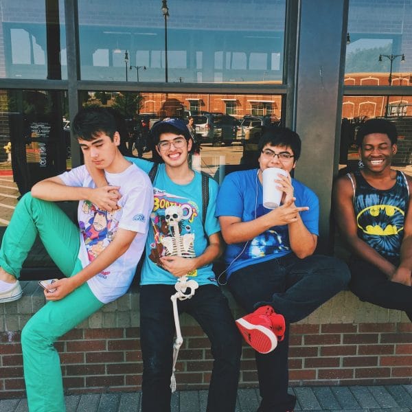Four teens sitting on window sill