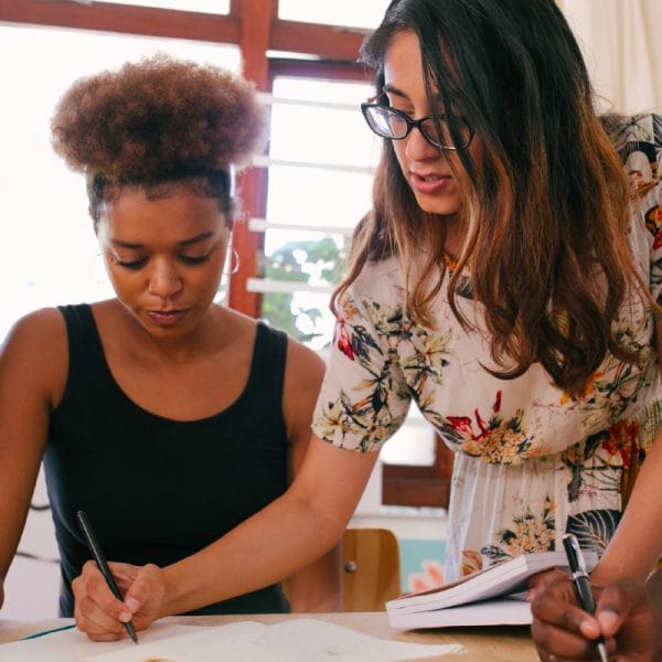 Woman writing in a notebook for a teen