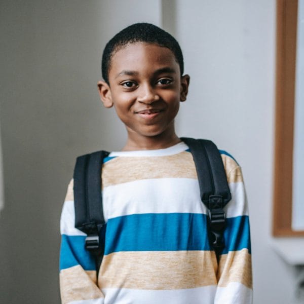 smiling-black-child-standing-in-classroom-and-looking-at-camera