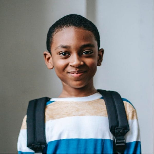 Young boy with backpack, smiling