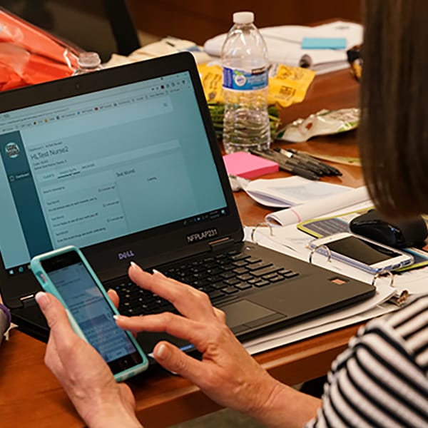 Woman holding while looking at a laptop