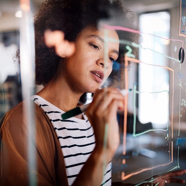 Woman making diagrams on glass