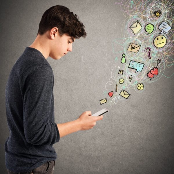 Teen boy writes on screen of his cellphone